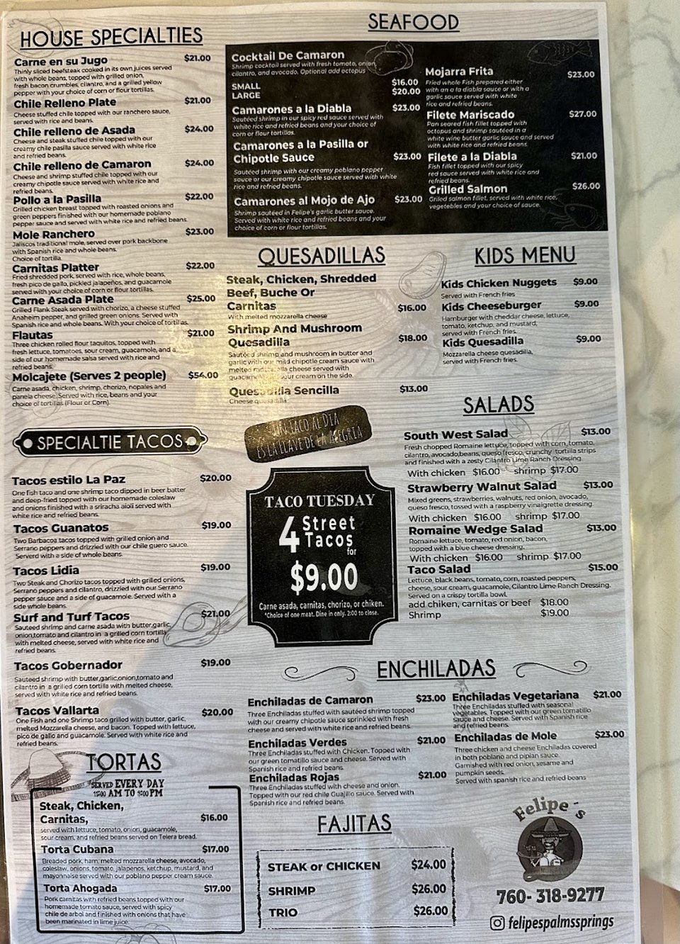 Restaurant menu beside a cocktail glass.